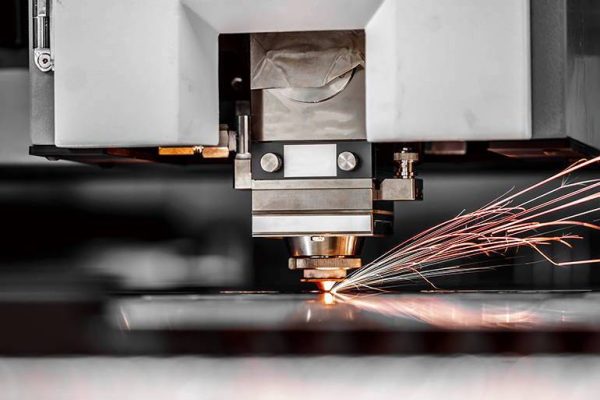CNC Laser cutting of metal, modern industrial technology. Small depth of field. Warning - authentic shooting in challenging conditions. A little bit grain and maybe blurred.